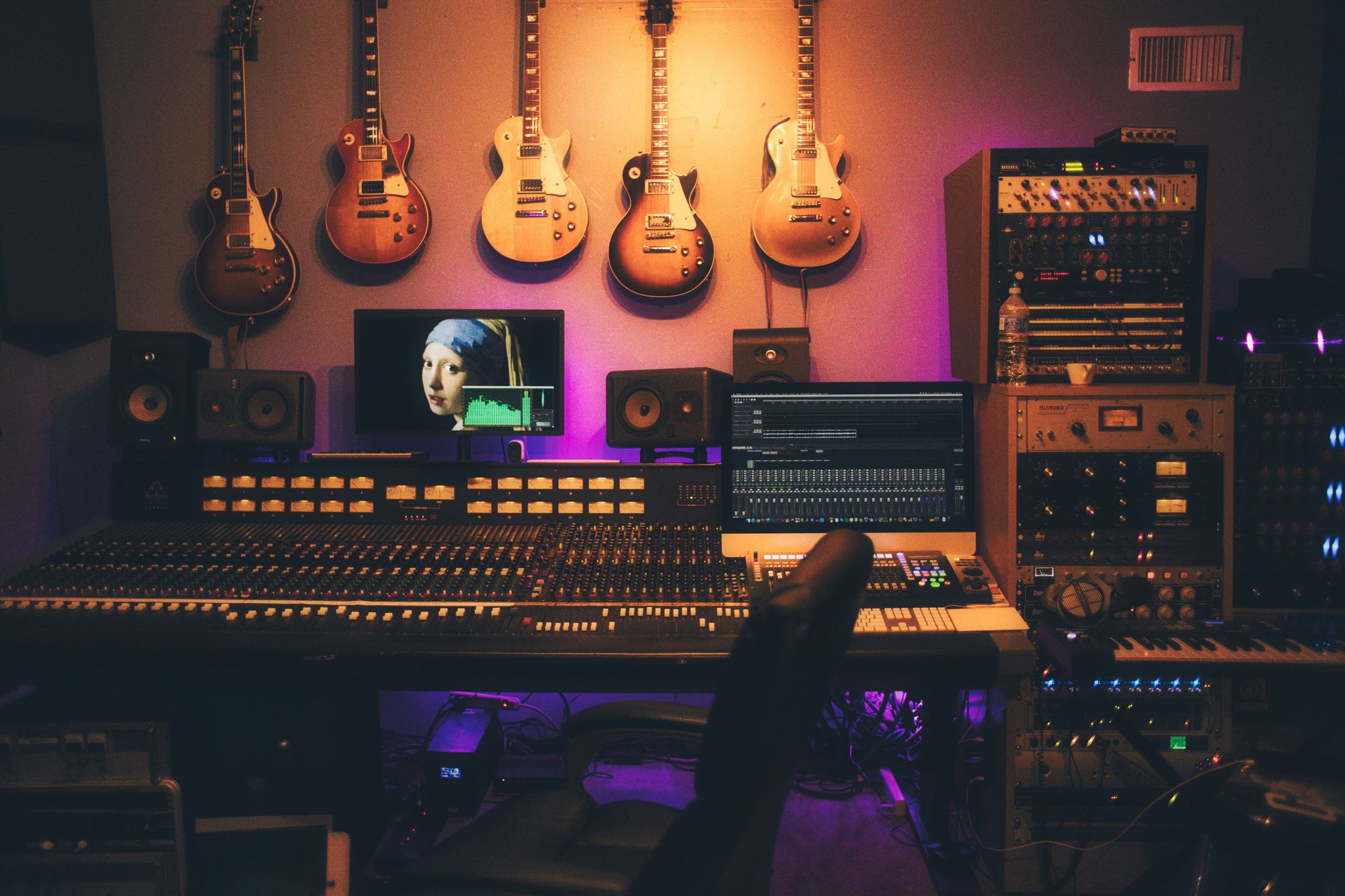 Guitars on the wall above a mixing desk in a recording studio